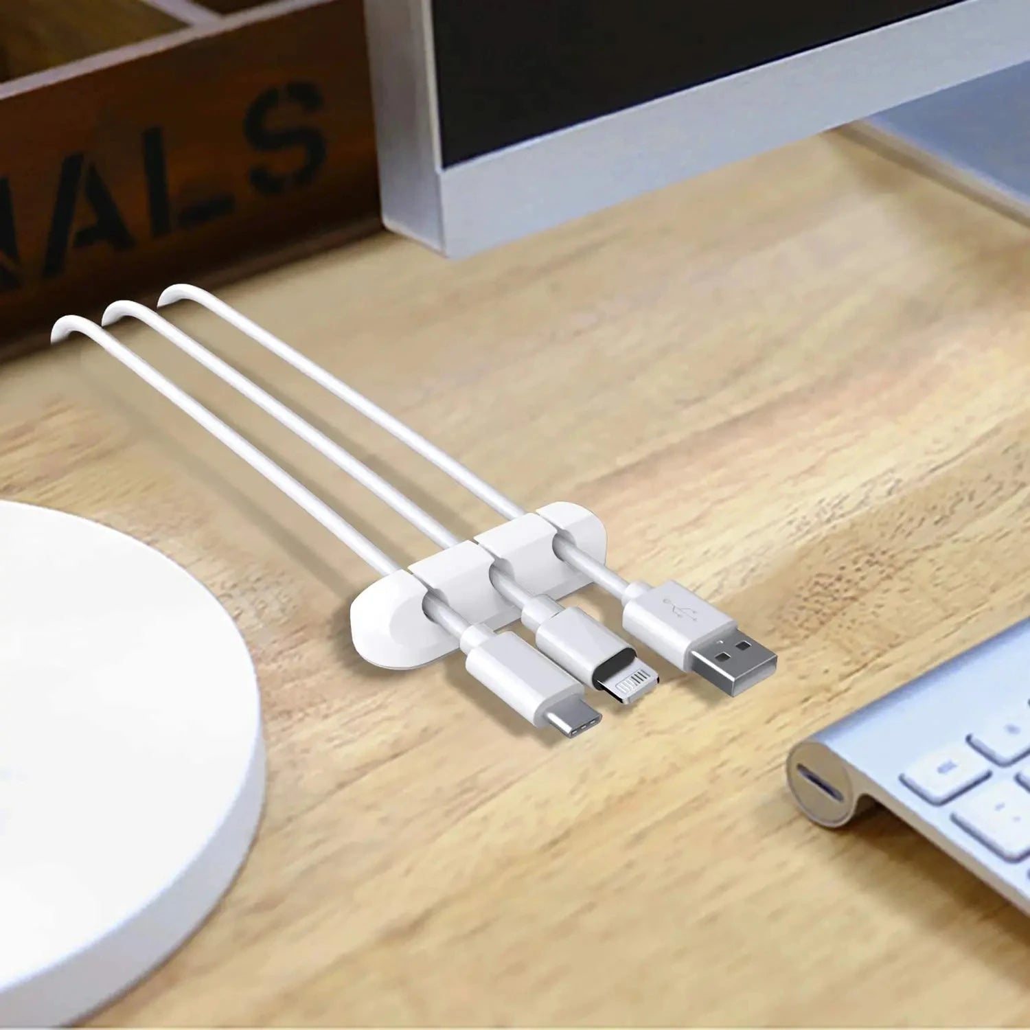 White silicone desk cable organizer clips holding USB charging cables in slots
